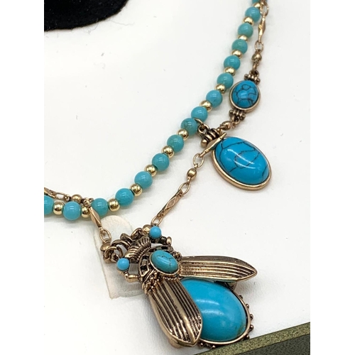 70 - An Egyptian revival set consisting of a double necklace, a matching pair
of earrings and a ring. In ... 