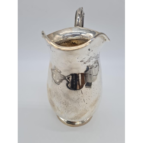 48 - A Silver Water Jug with Ornate Handle. 20cm Height. Weight: 628 grams