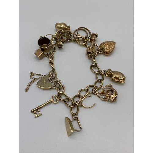 90 - 9ct Gold Charm Bracelet with 12 charms and Heart padlock 28.4g and 16cm length