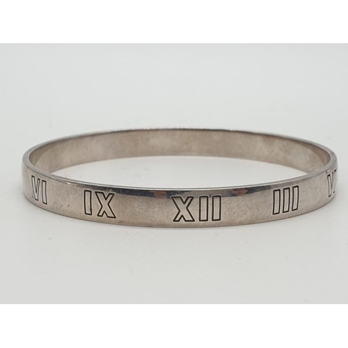 104 - Tiffany silver and diamond bangle with Roman numerals, weight 21.6g and 63mm width.