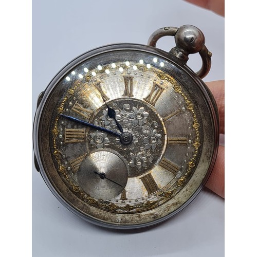 187 - Silver Pocket watch with ornate face and gold Roman Numerals rear wind circa 1880's, overwound