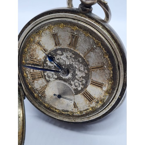 187 - Silver Pocket watch with ornate face and gold Roman Numerals rear wind circa 1880's, overwound