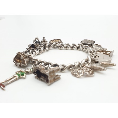 302 - Vintage silver charm bracelet with 12 charms and heart padlock, weight 63.65g and 18cm long approx