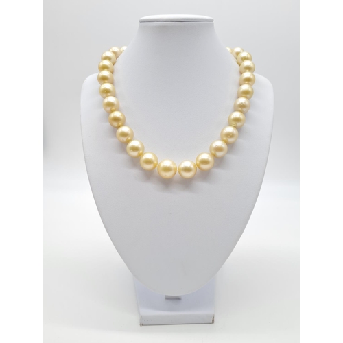 284 - Golden graduated south sea pearl set in 18ct yellow gold and diamond clasp, individually knotted pea... 