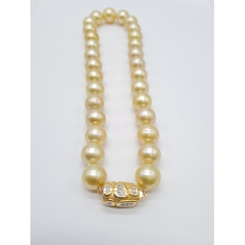 284 - Golden graduated south sea pearl set in 18ct yellow gold and diamond clasp, individually knotted pea... 