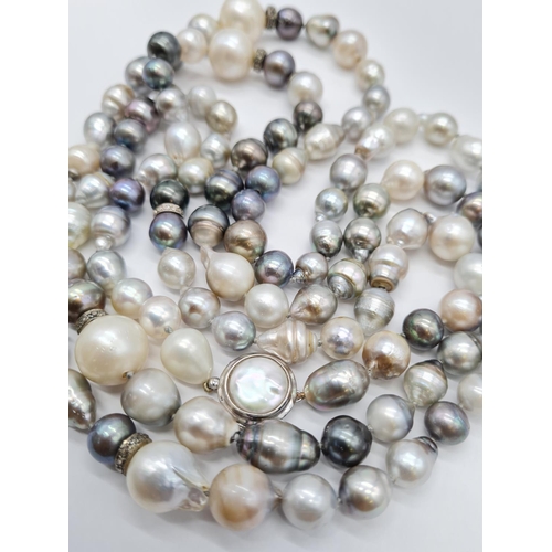 37 - A very long Cartier style pearl necklace set in 14ct gold mother of pearl clasp, various shades of b... 