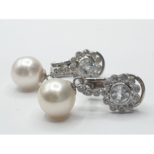 216 - Pair of 18ct gold pearl and white sapphire drop earrings in floral design, weight 6g and 2.5cm drop ... 