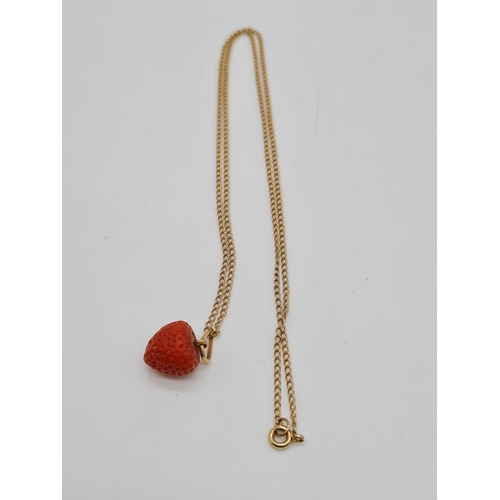 268 - Strawberry pendant set on yellow metal chain, weight 3.7g and 49cm long approx