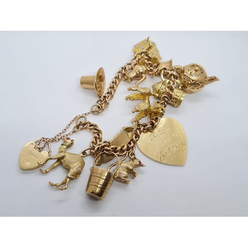 569 - 9ct gold vintage charm bracelet with 12 charms weight 53.3gram 18cm long with heart padlock.