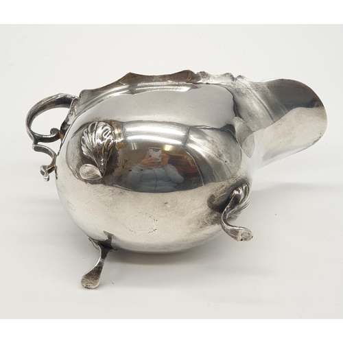 165 - Vintage silver sauce boat having scalloped rim and scroll handle, standing on three cabriole legs wi... 