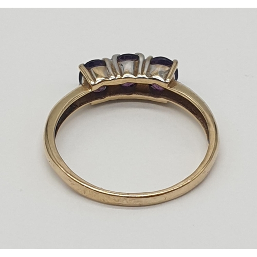 172 - 9ct gold ring having a dark amethyst trilogy to top, boxed full UK hallmark for Birmingham 9ct gold,... 