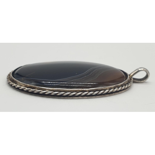 467 - Vintage large oval silver and agate pendant having a silver rope border with streaky brown agate to ... 