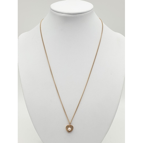 579 - 9ct gold heart pendant with a pearl on a 44cm 9ct chain.