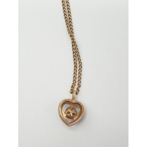 579 - 9ct gold heart pendant with a pearl on a 44cm 9ct chain.