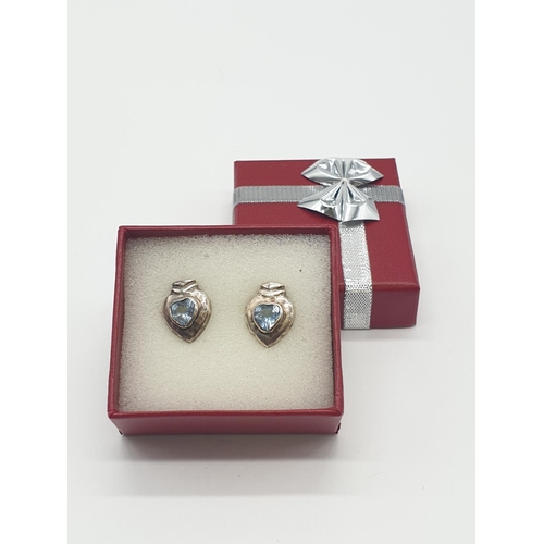 595 - Silver and Topaz blue earrings, having stones to centre with hammered silver surround, boxed