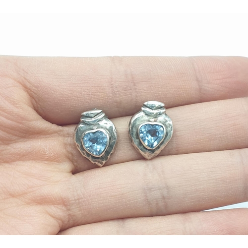 595 - Silver and Topaz blue earrings, having stones to centre with hammered silver surround, boxed