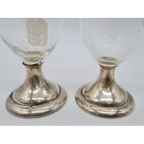 138 - Pair of silver bottomed glass vases. Weight 490g, 18cm tall.