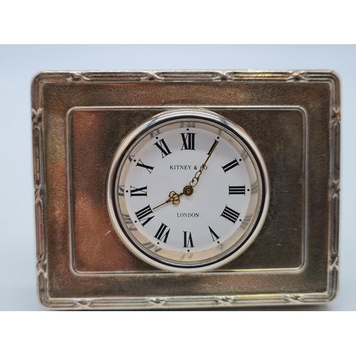 357 - Kitney and Co. miniature clock with silver surround. 7cm by 5cm.