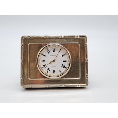 357 - Kitney and Co. miniature clock with silver surround. 7cm by 5cm.