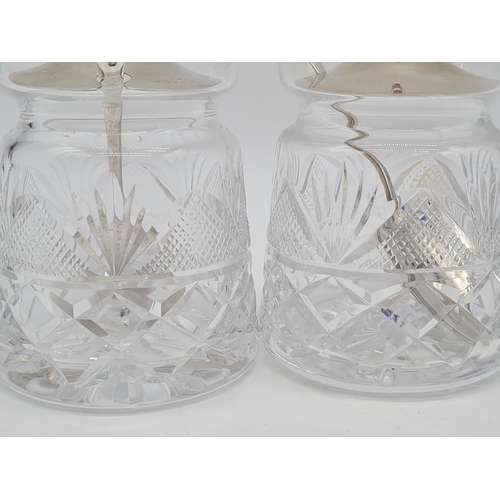 369 - Pair of cut glass silver lidded condiment jars with silver lid and silver spoon. 10cm high 483gm eac... 