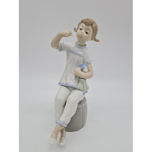 375 - Lladro girl with doll eating. 19cm tall.