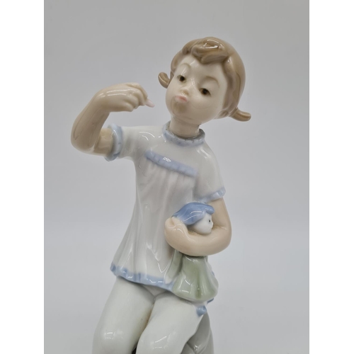 375 - Lladro girl with doll eating. 19cm tall.