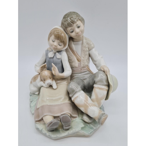 377 - Lladro boy cuddling girl, 17.5cm tall.