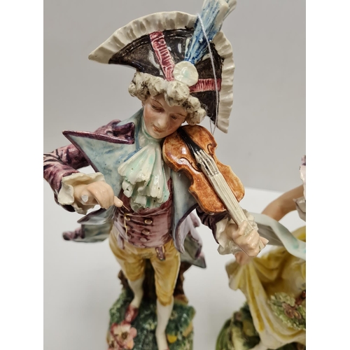 468 - Two tall ceramic figures of violin player and lady. Slight damage to to violin players hand.