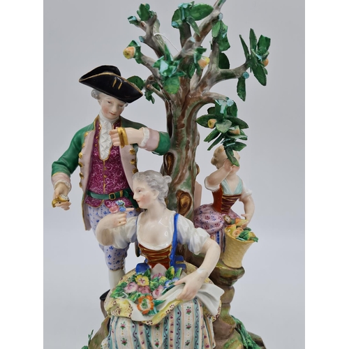 646 - Meissen statue of young family in garden. 26cm tall, width 19cm.