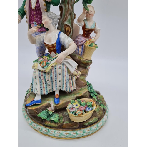 646 - Meissen statue of young family in garden. 26cm tall, width 19cm.