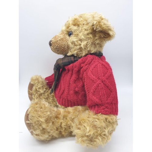 499 - Harrods 20th anniversary Teddy bear with a red knitted jumper and tartan scarf. Approx.  50cm tall.