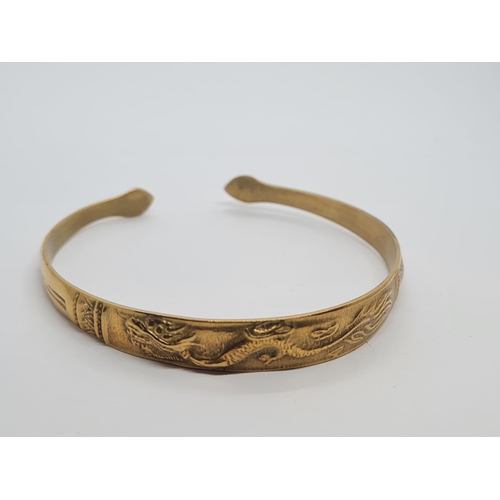 405 - Vintage yellow metal bangle, believed to be oriental with dragon motif. 14.5g.