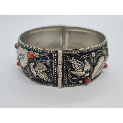 495 - A vintage Italian white metal bangle with cornellean and floral design. 43.5g.