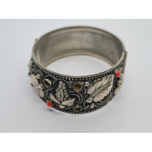 495 - A vintage Italian white metal bangle with cornellean and floral design. 43.5g.