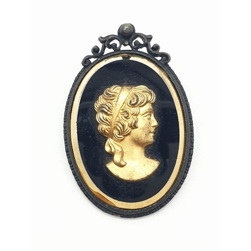 413 - 1950's Exquisite black brooch with gold coloured cameo. 25.2g, length 5cm.