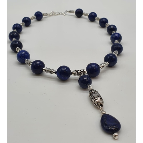 105 - A Tibetan silver and lapis lazuli necklace, earrings and bracelet in a presentation box. Necklace le... 