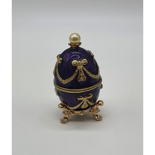 60 - A yellow metal (untested) Chinese dragon ring presented in Faberge style egg.