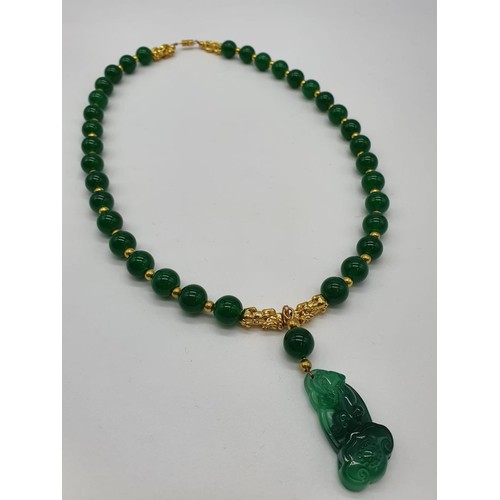 85 - A Chinese green jade and gold plated pixiu necklace and bracelet set in a presentation box. Necklace... 