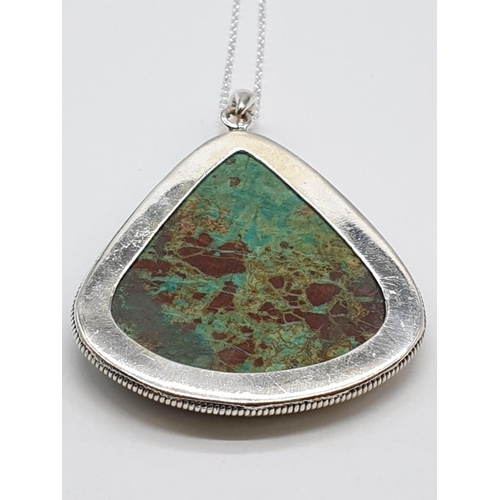 118 - Turquoise marbled stone pendant with silver chain. Length with chain 29cm. Stone Width 4.5cm Height ... 