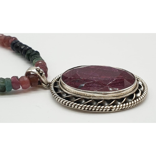 166 - A single strand tourmaline necklace with with ruby pendant in sterling silver. Length 27cm, 45.82g.