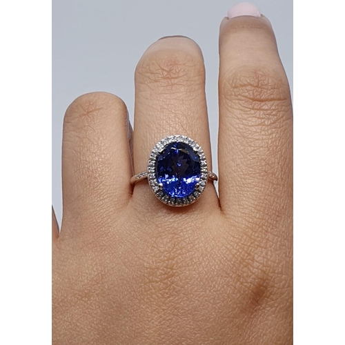 222 - 18ct white gold ring with 4ct tanzanite centre and encrusted diamond surrounding, weight 5.2g and si... 