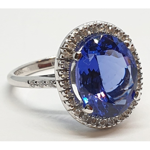 222 - 18ct white gold ring with 4ct tanzanite centre and encrusted diamond surrounding, weight 5.2g and si... 