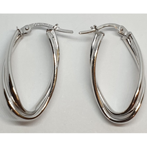 229 - 9ct White gold twist oval shaped hoop earrings. Weight 1.5g, Length 2.3cm