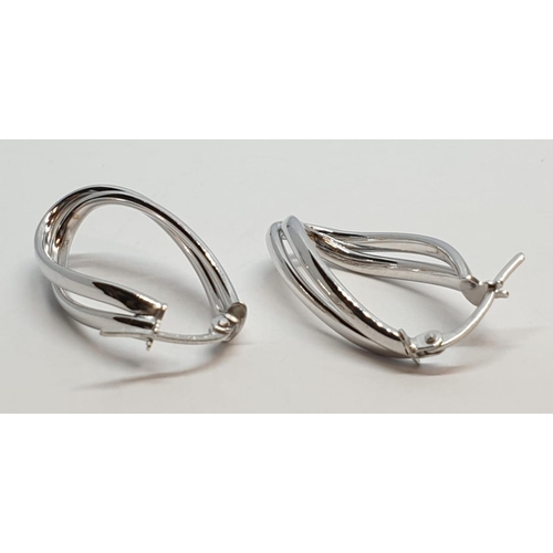 229 - 9ct White gold twist oval shaped hoop earrings. Weight 1.5g, Length 2.3cm