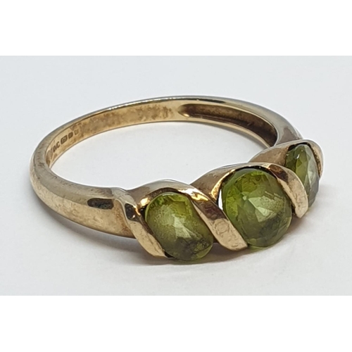 235 - 9ct Yellow gold three stone peridot ring. Weight 3g, Size P.