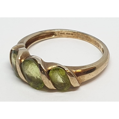 235 - 9ct Yellow gold three stone peridot ring. Weight 3g, Size P.