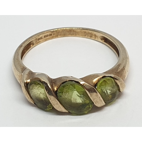 235 - 9ct Yellow gold three stone peridot ring. Weight 3g, Size P.