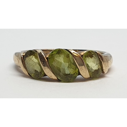 235 - 9ct Yellow gold three stone peridot ring. Weight 3g, Size P.