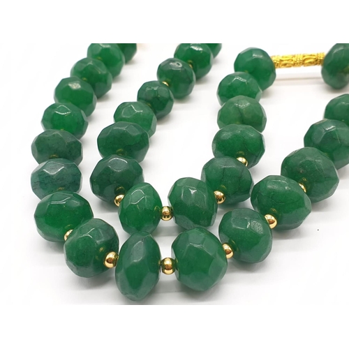 150 - A multifaceted, large beaded, opaque emerald necklace and earrings set in a presentation box. Neckla... 