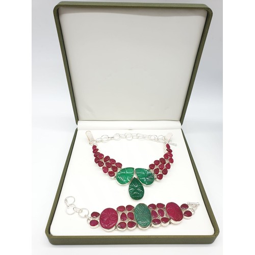 50 - An impressive carved emerald and ruby necklace and bracelet set. Presented in its own box. The stone... 